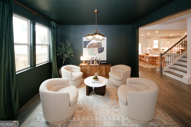 sitting room with recessed lighting, stairway, and wood finished floors