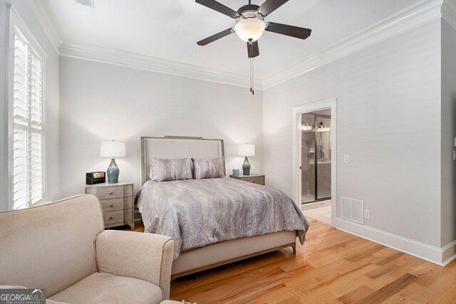 bedroom featuring ensuite bath, ornamental molding, ceiling fan, and light wood-type flooring