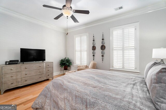 bedroom with light hardwood / wood-style flooring, ornamental molding, and ceiling fan