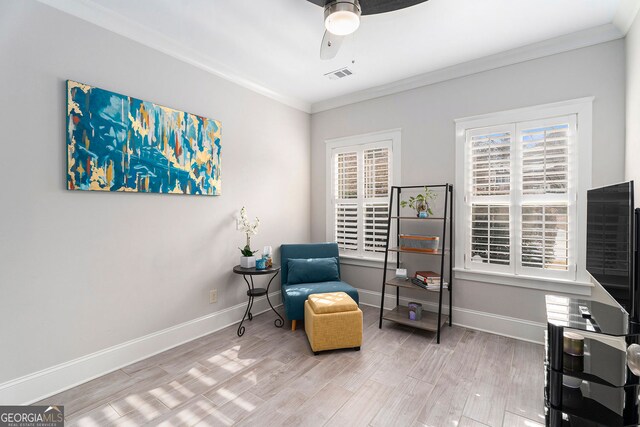 living area featuring wood-type flooring, ornamental molding, and ceiling fan