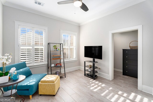 living area with ornamental molding and ceiling fan