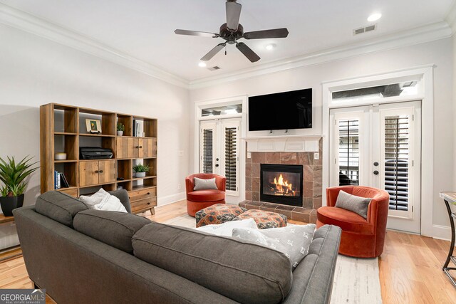 living room with ornamental molding, light hardwood / wood-style floors, and french doors