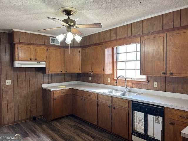 kitchen with sink, dishwasher, a textured ceiling, dark hardwood / wood-style flooring, and wood walls