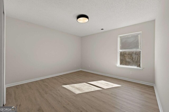 laundry room with electric dryer hookup, dark wood-type flooring, a textured ceiling, and an inviting chandelier