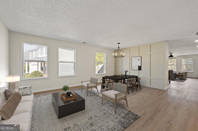 spare room with a notable chandelier, hardwood / wood-style flooring, and plenty of natural light