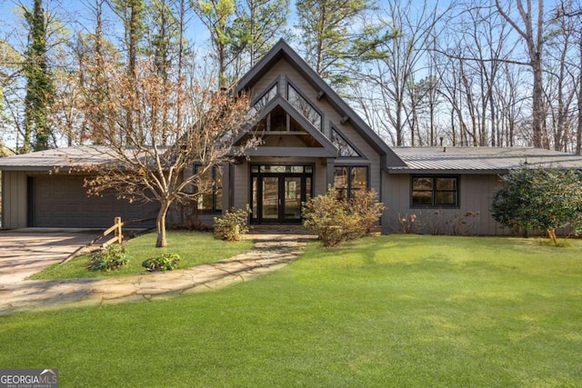 view of front of property with a garage, a front yard, and french doors