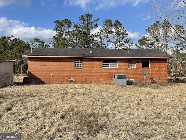 rear view of house with a lawn and central air condition unit