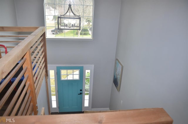 entryway featuring a towering ceiling and a notable chandelier