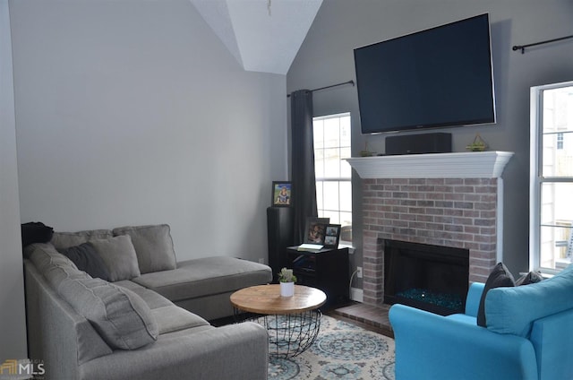 living room featuring lofted ceiling, hardwood / wood-style flooring, and a fireplace