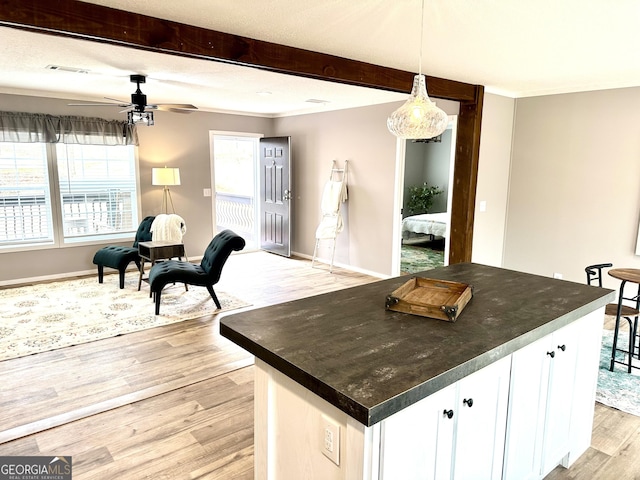 kitchen with white cabinetry, pendant lighting, a wealth of natural light, and light hardwood / wood-style floors