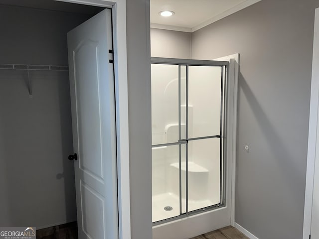 bathroom with wood-type flooring and a shower with shower door