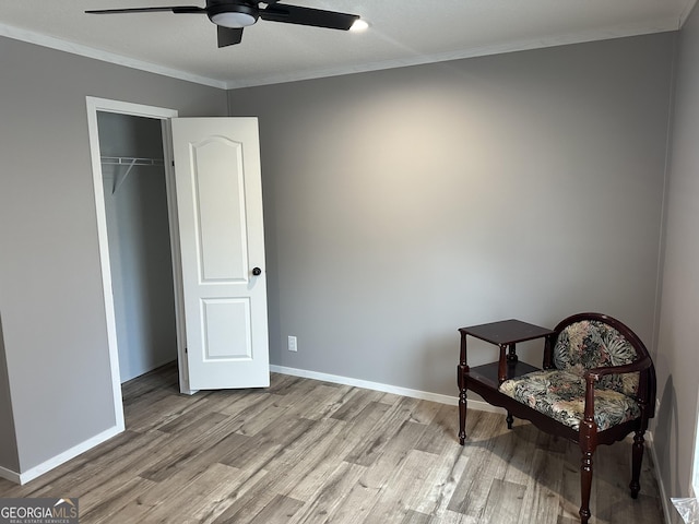 sitting room with ornamental molding, ceiling fan, and light wood-type flooring