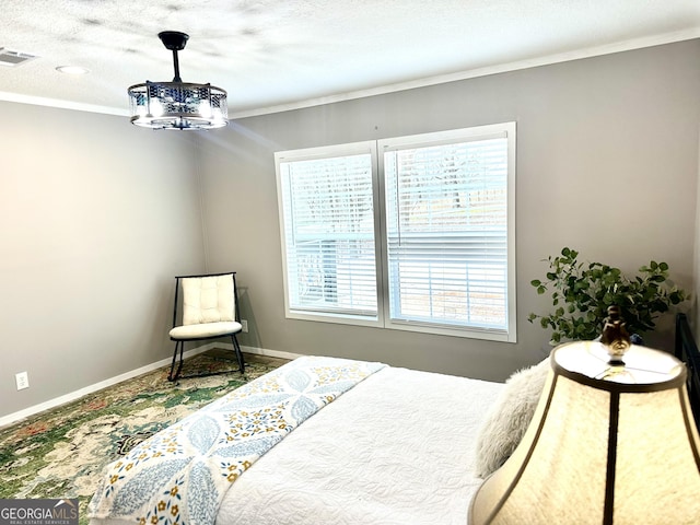 bedroom featuring a notable chandelier, ornamental molding, and a textured ceiling