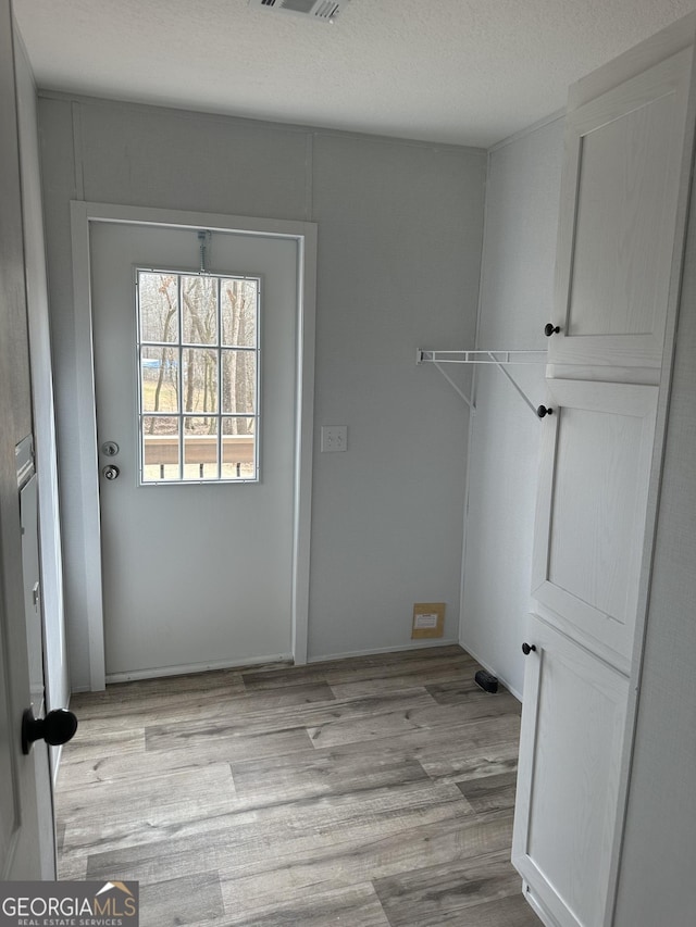 interior space with a textured ceiling and light wood-type flooring