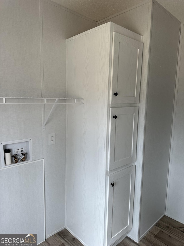 clothes washing area featuring cabinets, dark hardwood / wood-style floors, and washer hookup