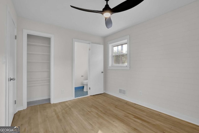 unfurnished bedroom featuring ensuite bath, light hardwood / wood-style flooring, and ceiling fan