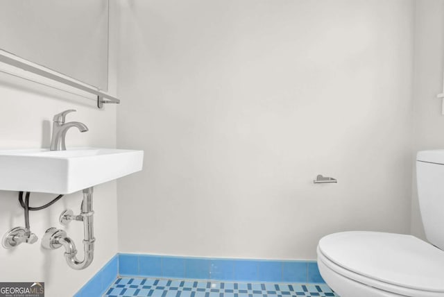 bathroom with tile patterned flooring, sink, and toilet