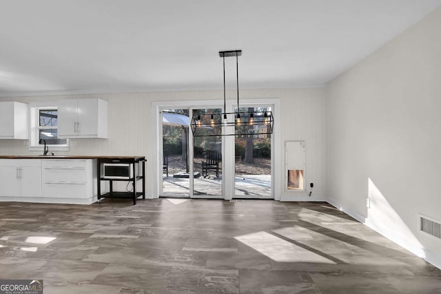 unfurnished dining area featuring a chandelier