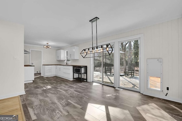 unfurnished dining area with sink and a chandelier