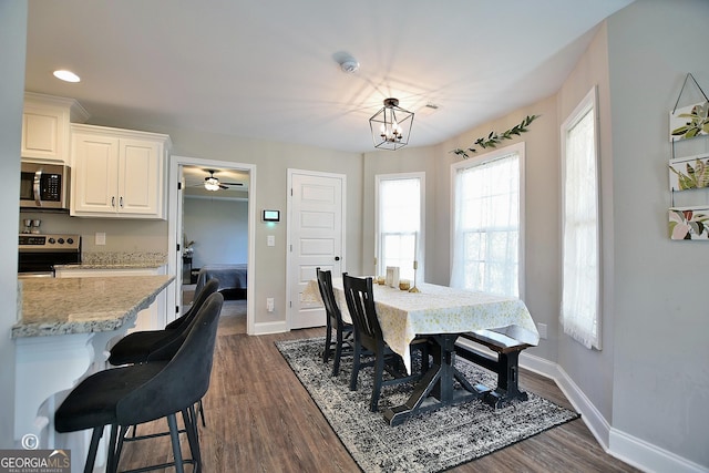 dining space featuring dark wood-type flooring and a chandelier