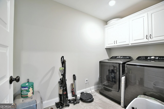 clothes washing area with cabinets, independent washer and dryer, and light tile patterned floors