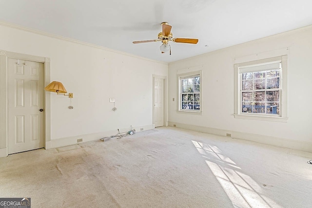 spare room with crown molding, ceiling fan, and light carpet