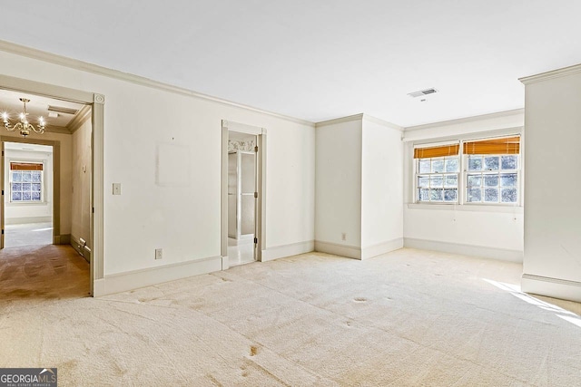 carpeted empty room featuring crown molding and an inviting chandelier