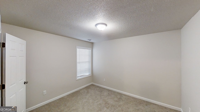 carpeted spare room with a textured ceiling