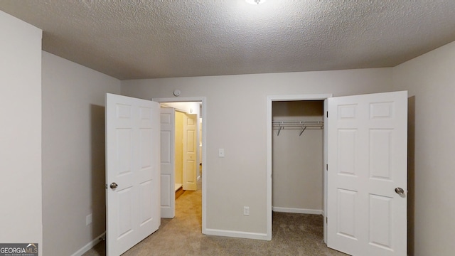 unfurnished bedroom featuring light colored carpet, a closet, and a textured ceiling