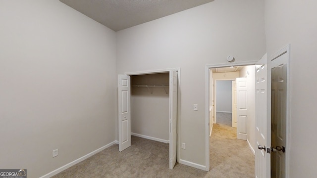 unfurnished bedroom featuring light carpet and a closet