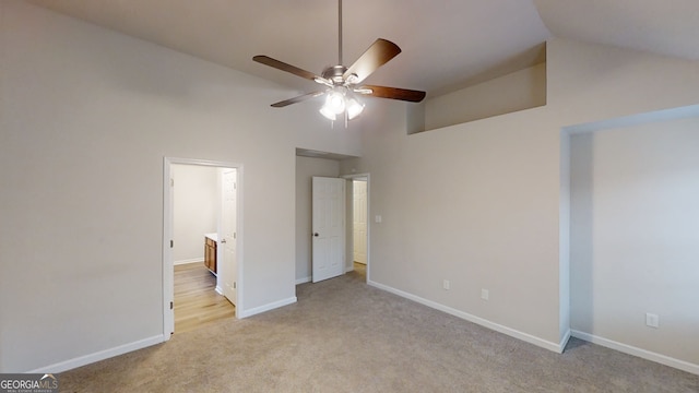 unfurnished bedroom with ceiling fan, connected bathroom, high vaulted ceiling, and light carpet