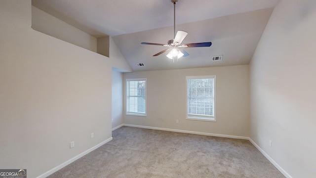 spare room with lofted ceiling, light colored carpet, and ceiling fan