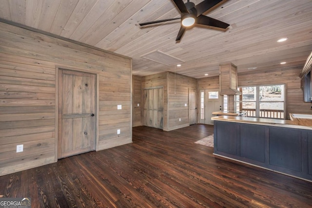 kitchen featuring ceiling fan, wooden walls, wood ceiling, and dark hardwood / wood-style flooring