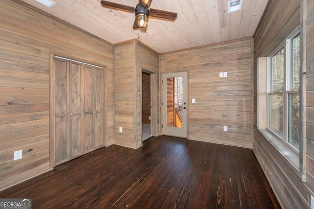 unfurnished room with wood ceiling, wooden walls, dark hardwood / wood-style floors, and ceiling fan