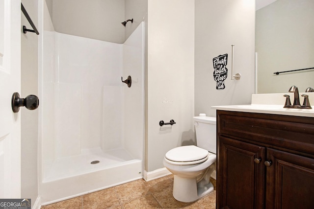 bathroom with tile patterned flooring, vanity, a shower, and toilet