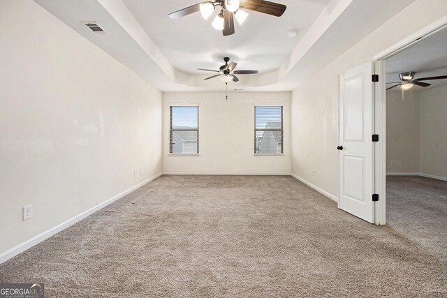 carpeted empty room with a tray ceiling