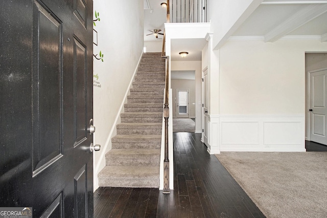 foyer entrance with crown molding and dark hardwood / wood-style floors