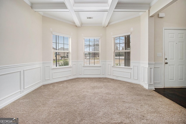 carpeted spare room with beamed ceiling, ornamental molding, and coffered ceiling