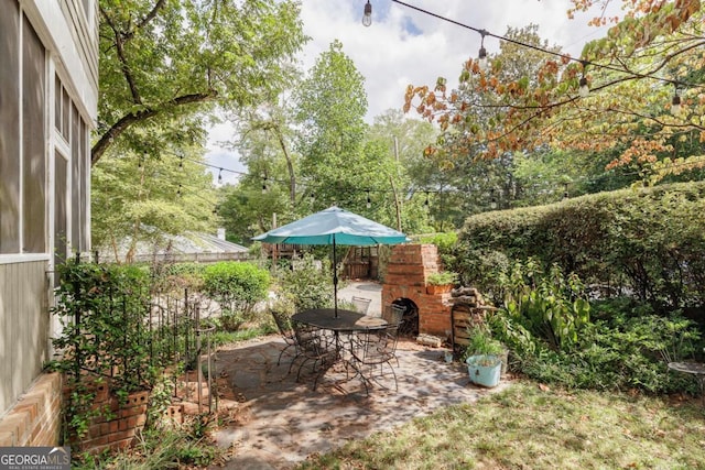 view of yard featuring exterior fireplace and a patio area