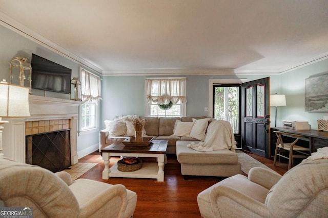 living room with hardwood / wood-style flooring, ornamental molding, and a tile fireplace