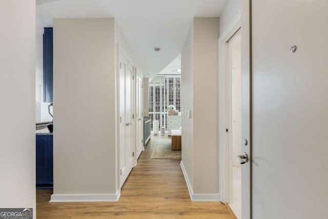 hallway with baseboards and light wood finished floors