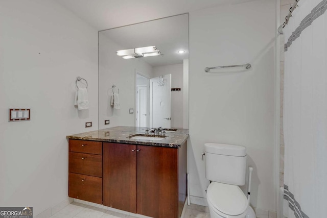 bathroom featuring toilet, baseboards, and vanity