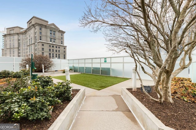 surrounding community with fence and a yard