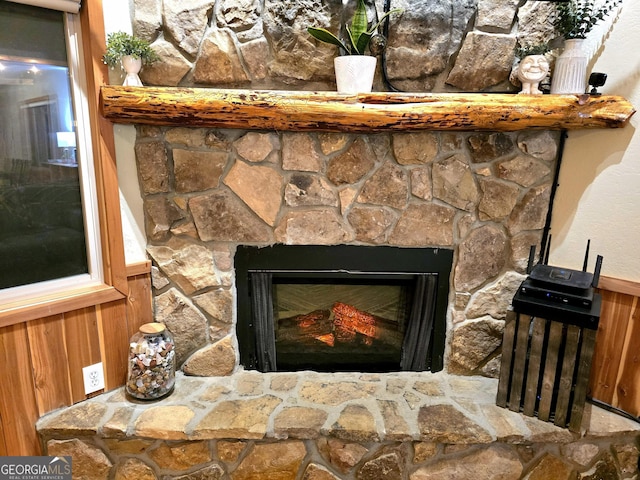 details with a wainscoted wall, wood walls, and a fireplace