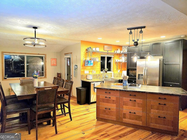 kitchen featuring light wood-style flooring, dishwasher, a textured ceiling, and stainless steel fridge with ice dispenser