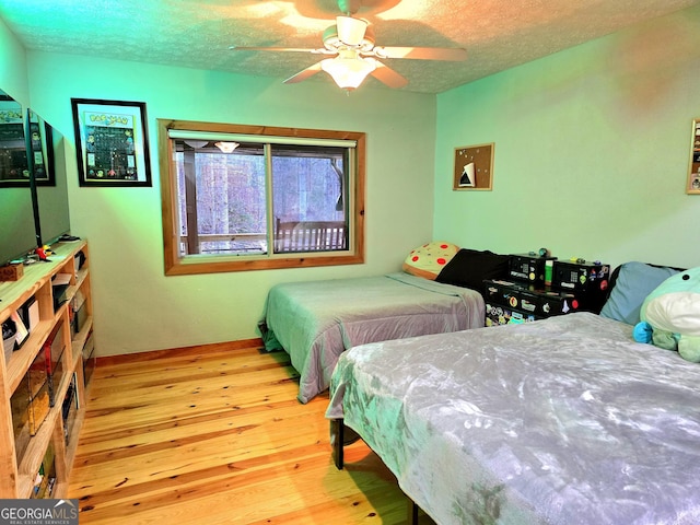 bedroom with a textured ceiling, ceiling fan, and wood-type flooring