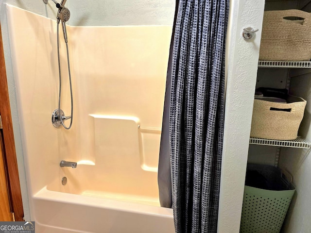 bathroom featuring a textured ceiling and shower / tub combo with curtain