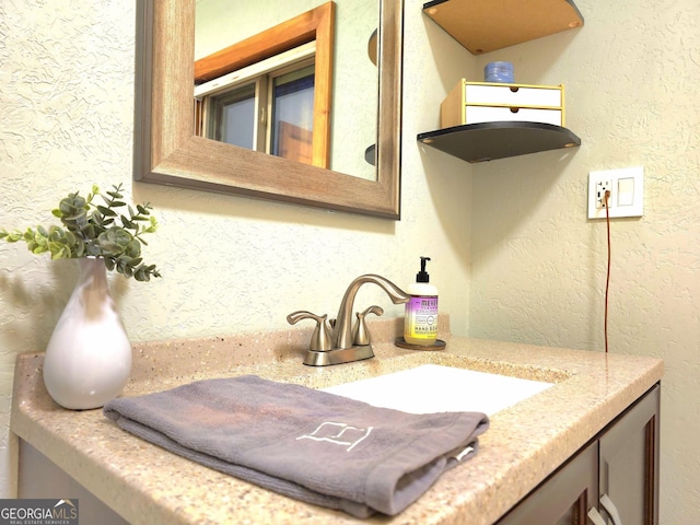 bathroom with vanity and a textured wall