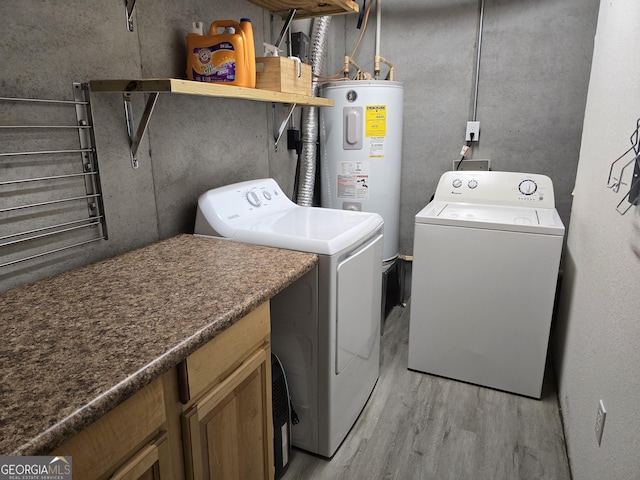 clothes washing area featuring independent washer and dryer, light wood-style flooring, and water heater