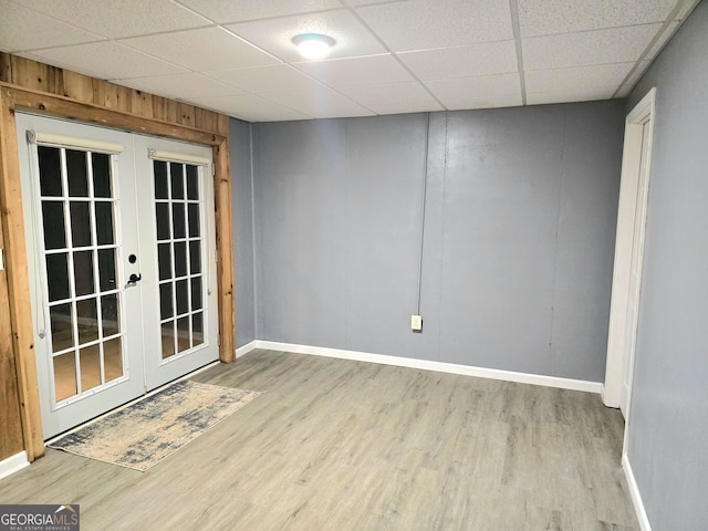 unfurnished room featuring a drop ceiling, wood finished floors, and french doors